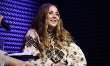 Жінка з довгим волоссям у вишиванці посміхається.