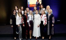 Група жінок у вишиванках позують для фото, на задньому фоні - екран.