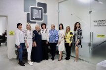 Жінки у вишитому одязі позують для фото у приміщенні.