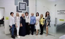 Жінки у вишитому одязі позують для фото у приміщенні.