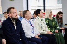 Люди у вишиванках сидять у приміщенні.