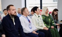 Люди у вишиванках сидять у приміщенні.