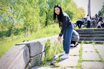 Жінка прибирає бур’яни під час толоки в парку.