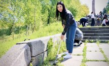 Жінка прибирає бур’яни під час толоки в парку.