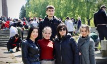 Чотири жінки та хлопець позують надворі.