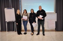 Чоловік та троє жінок позують для фото у приміщенні.