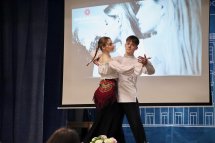 Пара виконує танець на сцені перед екраном.