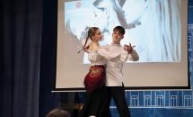 Пара виконує танець на сцені перед екраном.