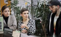 Жінка у діловому одязі розповідає щось для інших людей.
