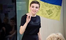 Жінка у чорному одязі щось розповідає.