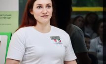 Жінка у білому одязі з бейджем щось розповідає.