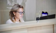 Жінка в окулярах працює за комп'ютером.