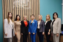 Сім жінок у діловому одязі позують для фото.
