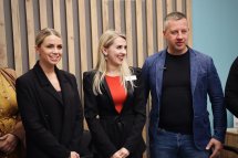Чоловік та двоє жінок посміхаються.