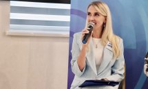 Жінка із світлим волоссям розповідає щось в мікрофон.
