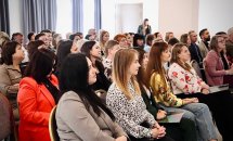 Багато людей сидять у приміщенні.