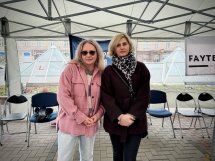 Дві жінки стоять під наметом