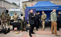 Військові та поліцейські біля намету з технікою та озброєнням
