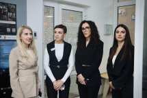 Чотири жінки у діловому одязі перебувають у приміщенні.
