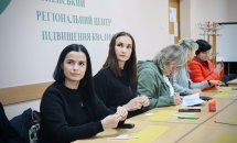 Група жінок сидять за столом у приміщенні.
