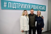 Чоловік та дві жінки посміхаються.