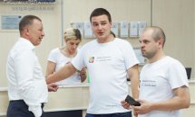 Троє чоловіків у білому одязі комунікують між собою.