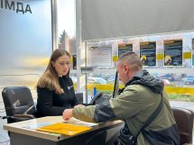 Жінка сидить за робочим столом, напроти неї сидить чоловік.