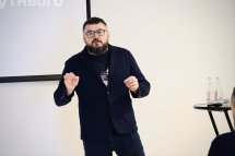 Чоловік з бородою щось розповідає.