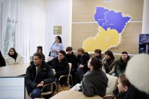 Група людей сидить у кабінеті.