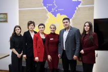 Група людей позує для фото у приміщенні.