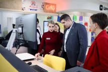 Група людей стоять біля комп'ютера.