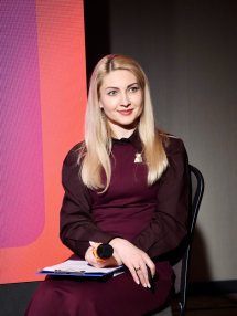 Жінка зі світлим волоссям тримає мікрофон у руках