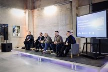 П'ять чоловіків сидять перед екраном.