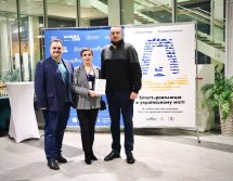 Два чоловіка та жінка стоять на фоні банера.