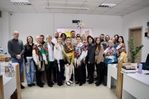 Група людей у вишитих сорочках позує для фото.