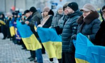 Люди тримають прапори України.