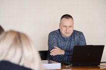 Чоловік сидить за ноутбуком.