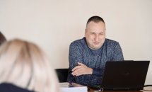 Чоловік сидить за ноутбуком.