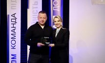 Жінка в чорному піджаку та чоловік тримають подяку