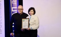 Чоловік в окулярах стоїть біля жінки з нагородою в руках