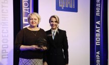 Двоє жінок позують та тримають нагороду у руках