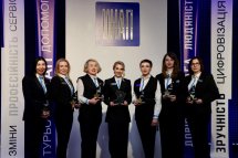 Сім жінок в діловому одязі позують для спільного фото