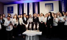 Багато людей перебуває у залі, перед ними торт