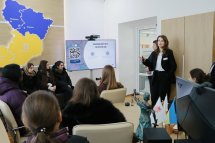 Жінка щось розповідає групі осіб