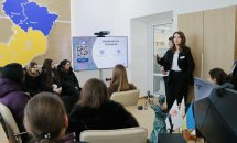 Жінка щось розповідає групі осіб