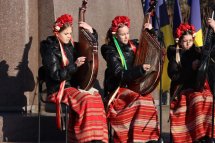 Три дівчинки в українських костюмах тримають бандури.