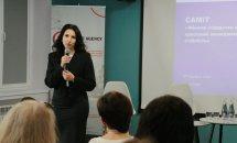 Жінка з темним волоссям тримає мікрофон руках.