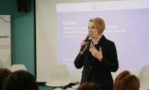 Жінка з коротким волоссям тримає мікрофон у руках.