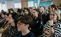 Багато жінок сидять у приміщенні.