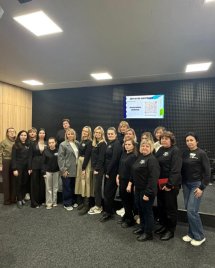 Групове фото жінок на фоні звукоізолюючої стіни та телевізору.